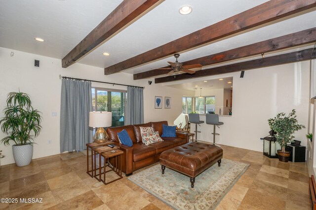 kitchen featuring a kitchen bar, sink, tasteful backsplash, ceiling fan, and beam ceiling