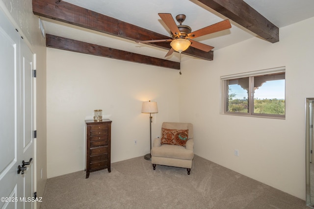 sitting room featuring carpet, beamed ceiling, and ceiling fan