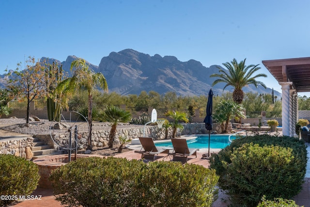 view of swimming pool with a patio, fence, a mountain view, and a fenced in pool