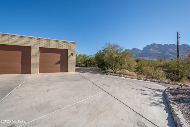 view of side of property with a garage, an outdoor structure, and a mountain view