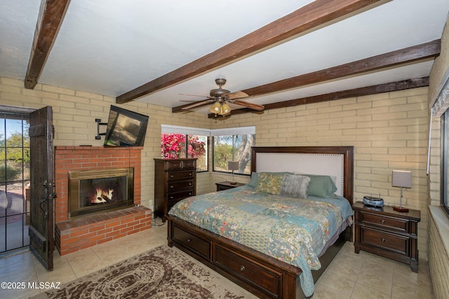 bedroom featuring ceiling fan, light tile patterned floors, brick wall, a brick fireplace, and beamed ceiling