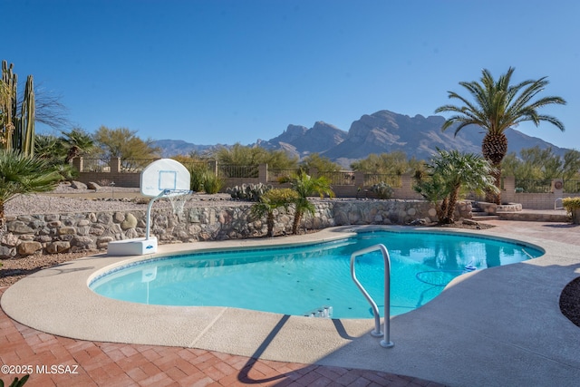 view of swimming pool featuring a patio, fence, a mountain view, and a fenced in pool