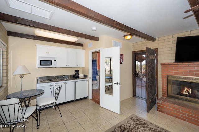 kitchen with white appliances, visible vents, white cabinets, and beamed ceiling