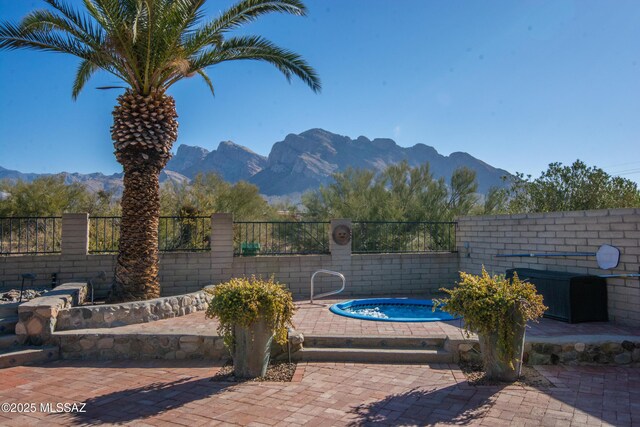 view of swimming pool with a patio and a mountain view