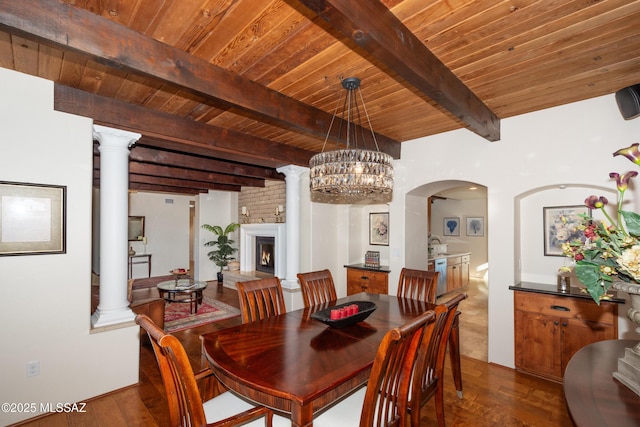 dining area featuring wooden ceiling, ornate columns, and dark wood-type flooring