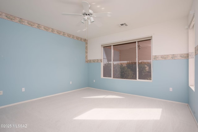 empty room with baseboards, carpet, visible vents, and a ceiling fan