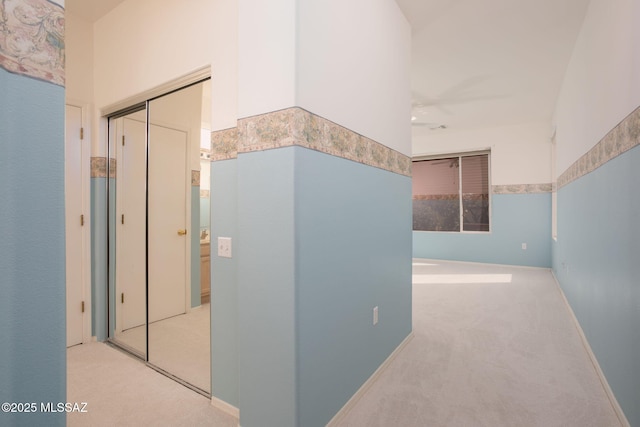 corridor with baseboards and carpet flooring