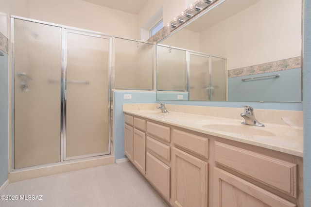 bathroom featuring double vanity, a sink, and a shower stall