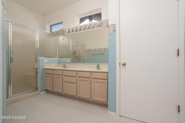 bathroom featuring double vanity, a stall shower, and a sink