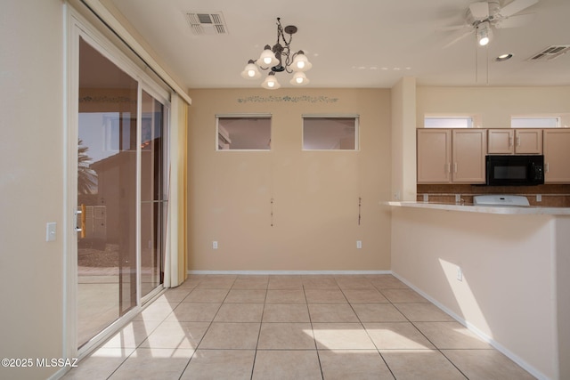 kitchen with light tile patterned floors, visible vents, black microwave, and ceiling fan with notable chandelier