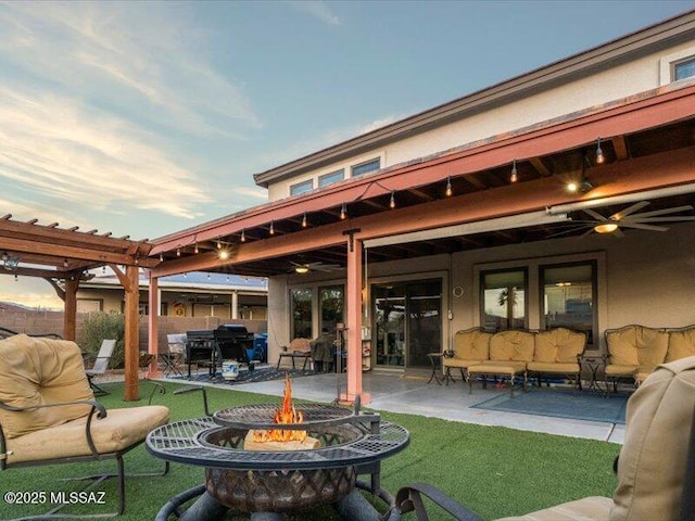 patio terrace at dusk featuring an outdoor living space with a fire pit and ceiling fan