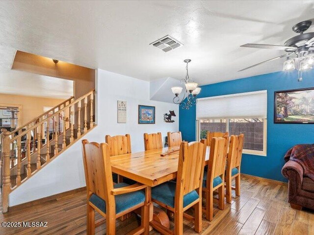 dining area featuring ceiling fan with notable chandelier, a textured ceiling, and light wood-type flooring