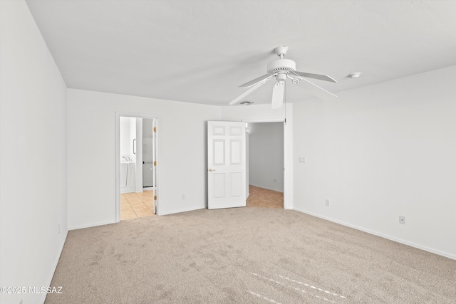 unfurnished bedroom with ceiling fan, ensuite bathroom, and light colored carpet