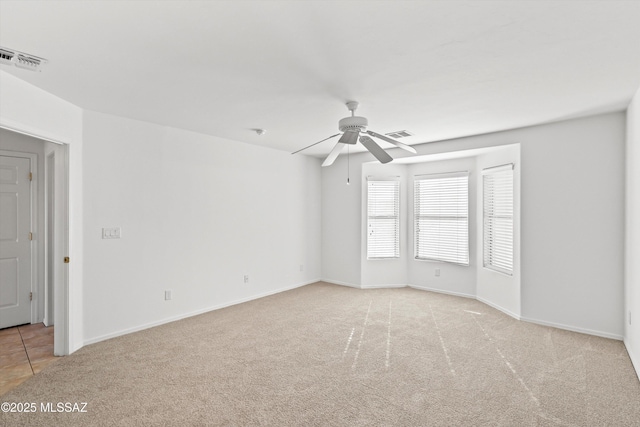 empty room with light colored carpet and ceiling fan