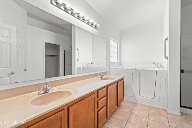 bathroom with vanity, a tub, and tile patterned floors