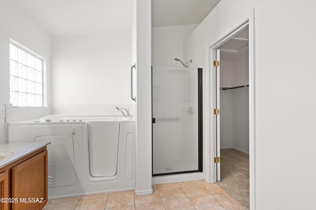 clothes washing area with light tile patterned flooring and washer and dryer