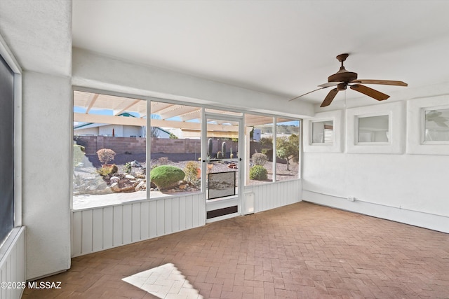 unfurnished sunroom with ceiling fan and plenty of natural light