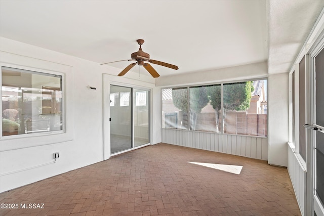 unfurnished sunroom with ceiling fan