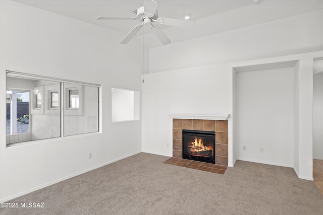 unfurnished living room with ceiling fan, a tile fireplace, plenty of natural light, and light carpet