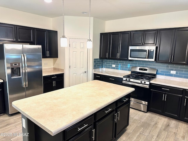 kitchen featuring stainless steel appliances, a kitchen island, pendant lighting, and decorative backsplash