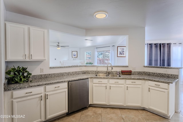 kitchen featuring sink, dishwashing machine, and white cabinets