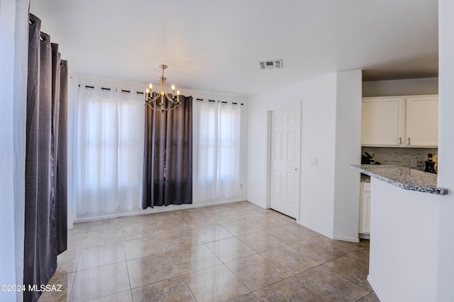 interior space with an inviting chandelier and light tile patterned flooring