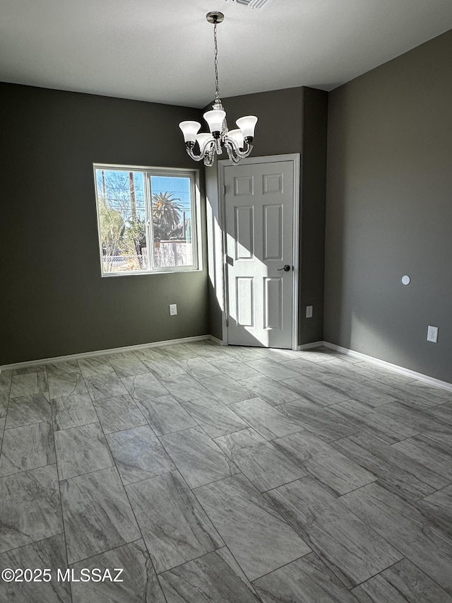 spare room featuring an inviting chandelier