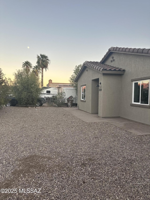 property exterior at dusk with a patio