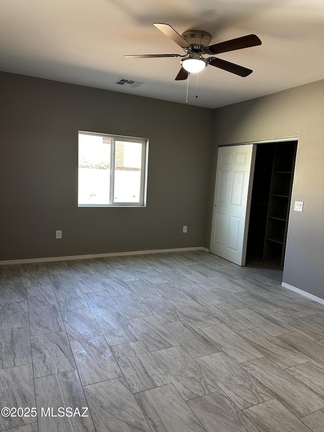 unfurnished bedroom with ceiling fan and a closet