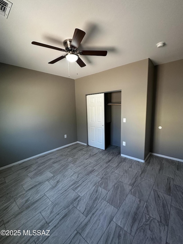 unfurnished bedroom with ceiling fan and a closet