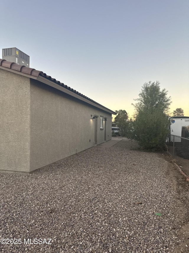 property exterior at dusk with cooling unit