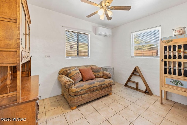 sitting room with an AC wall unit, light tile patterned floors, and ceiling fan