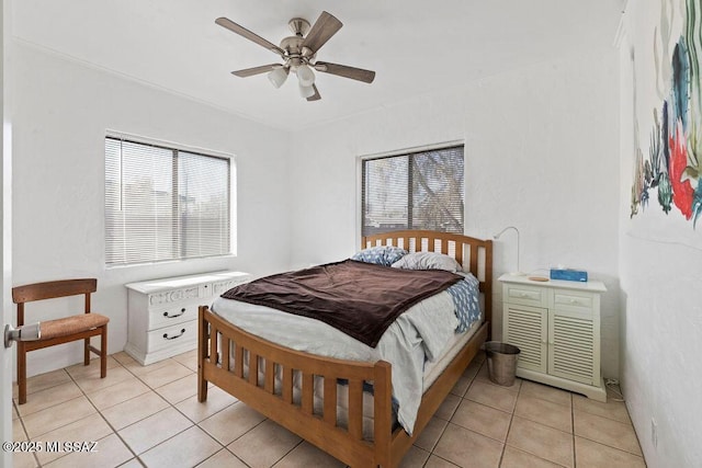 bedroom featuring ceiling fan, multiple windows, and light tile patterned floors