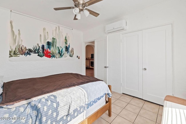 tiled bedroom with a wall mounted air conditioner, ceiling fan, and a closet