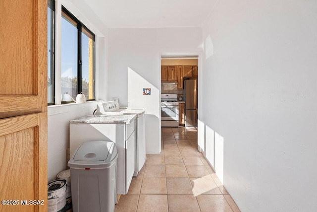 washroom featuring light tile patterned flooring and washer / dryer