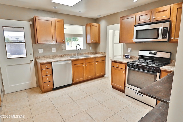 kitchen featuring stainless steel appliances, light tile patterned flooring, and sink