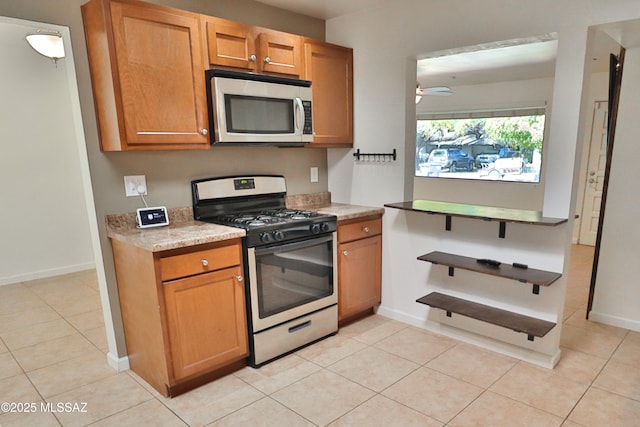 kitchen with ceiling fan, appliances with stainless steel finishes, and light tile patterned floors