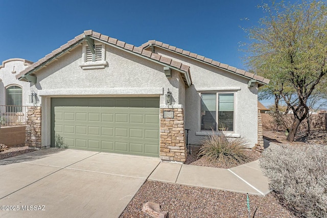 view of front of property with concrete driveway, stone siding, a tile roof, an attached garage, and stucco siding