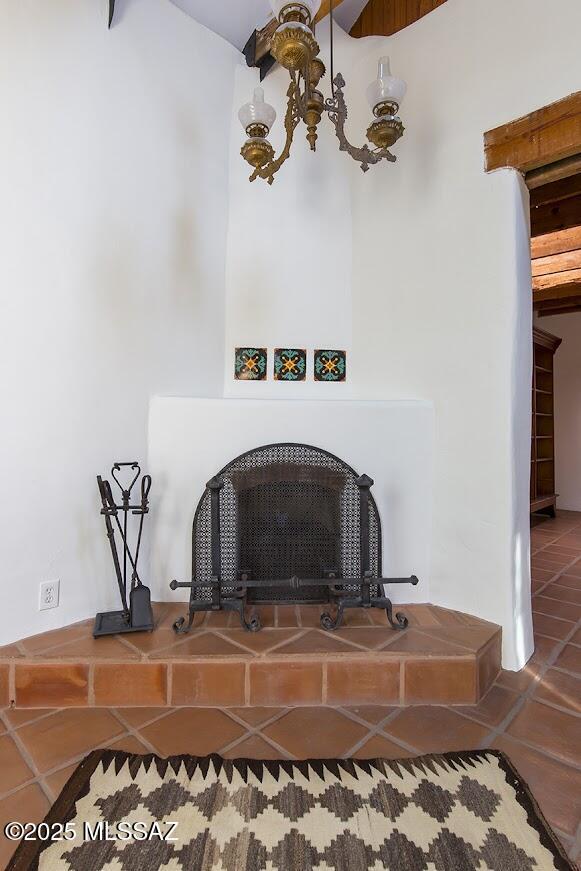 interior details featuring a tile fireplace and a chandelier