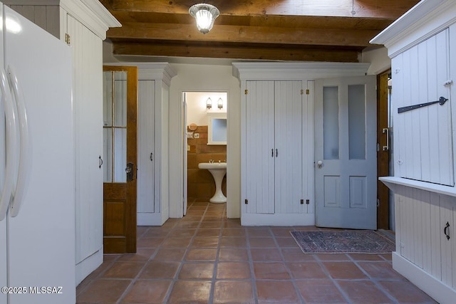 bathroom with beamed ceiling and tile patterned flooring