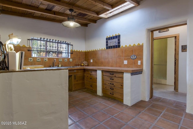 kitchen featuring sink, beam ceiling, a high ceiling, wood ceiling, and decorative backsplash