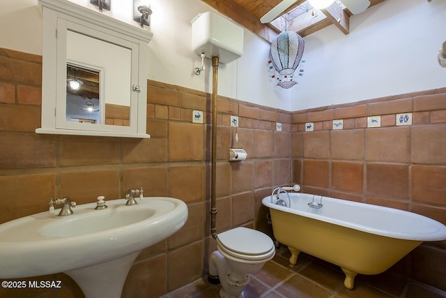 bathroom with toilet, tile walls, tile patterned flooring, a bath, and backsplash