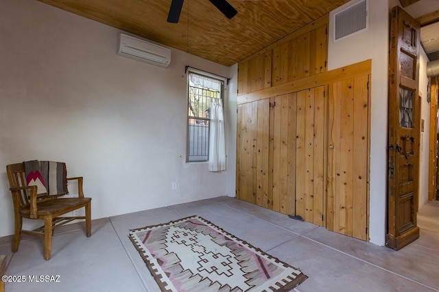 interior space featuring concrete floors, an AC wall unit, wooden walls, and wooden ceiling