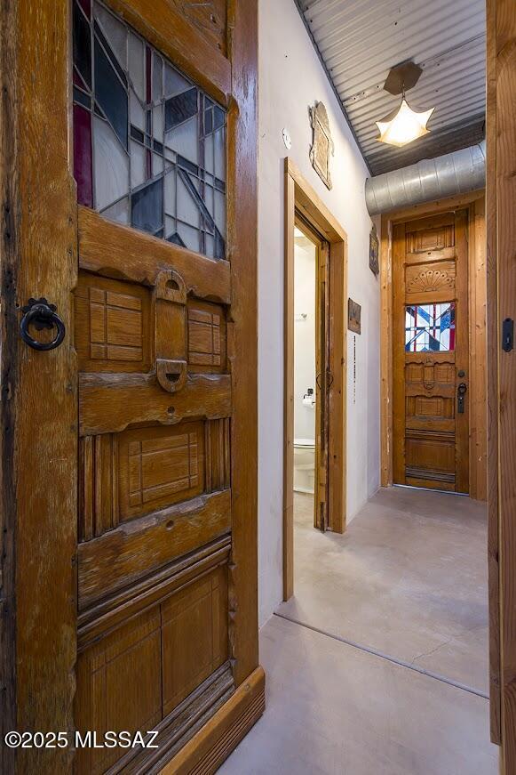 hallway with concrete floors and wooden ceiling