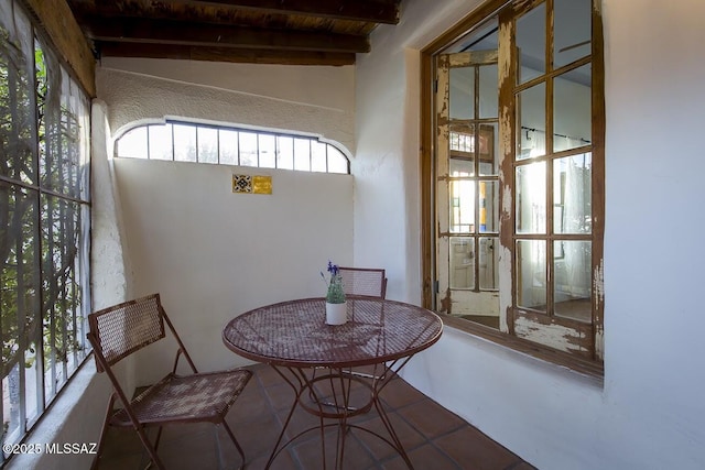 sunroom featuring vaulted ceiling with beams and wooden ceiling