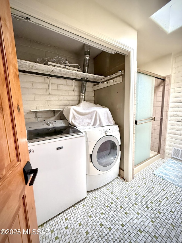 laundry area with a skylight and washer and dryer