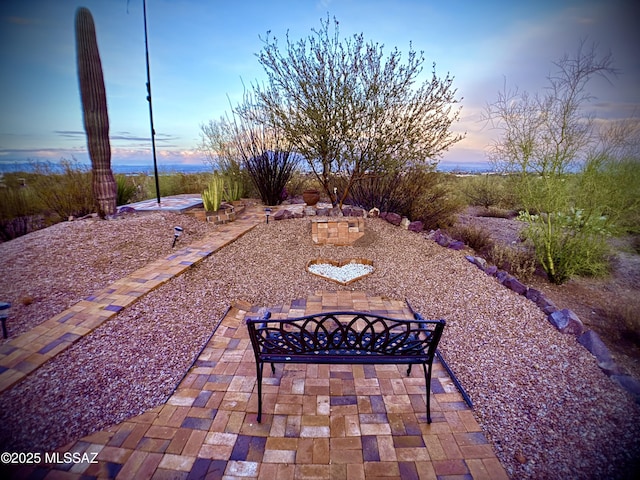 yard at dusk featuring a patio