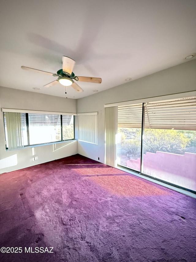 spare room with ceiling fan and carpet