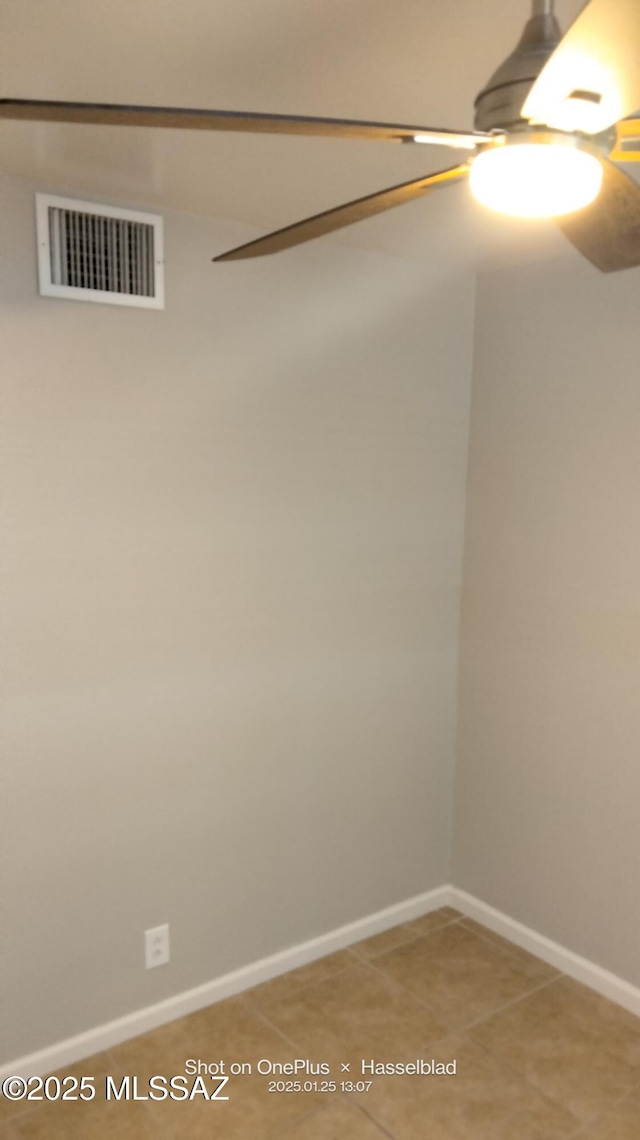 tiled spare room with ceiling fan