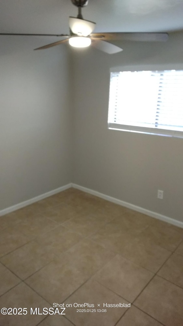 empty room featuring tile patterned floors and ceiling fan